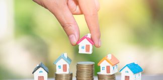 Mini houses on stack of coins