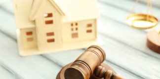 Gavel and miniature house on wooden background. Auction concept