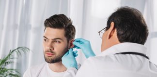 Doctor examining male patient's ear