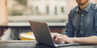 Man using a laptop on an outdoor table