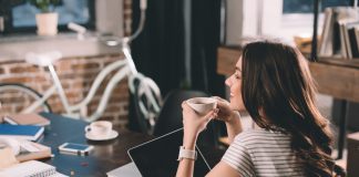 Woman with laptop drinking coffee