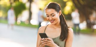 Happy woman texting on phone