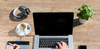 Person sitting at workspace with laptop