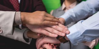 Employees putting hands together in strength