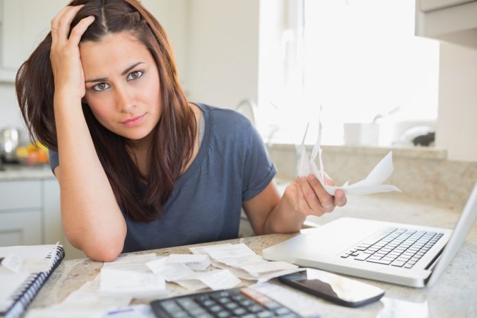 Woman looking worried over finances in kitchen