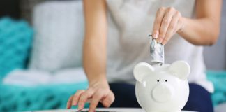 Person putting money in piggy bank