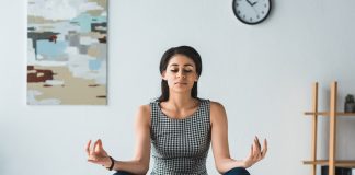 Businesswoman practicing yoga in office