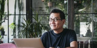 Smiling man working on laptop at home