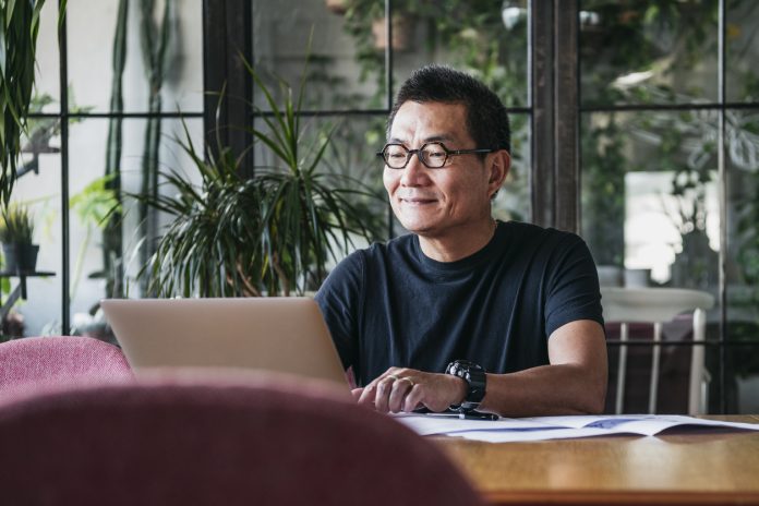 Smiling man working on laptop at home