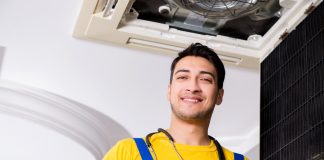 Repairman Repairing Ceiling Air Conditioning Unit