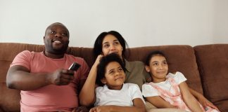 Family sitting on couch watching TV