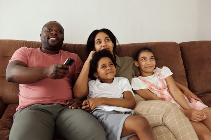 Family sitting on couch watching TV