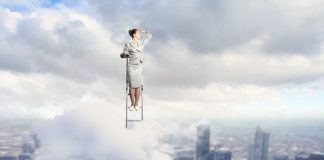 Businesswoman standing on ladder