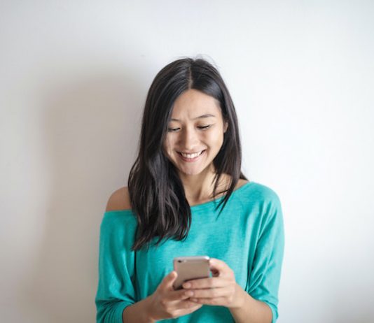 Woman Smiling at Smartphone