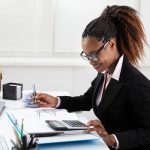 Tips for Spring Cleaning Your Business Businesswoman Using Calculator
