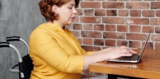 Woman in Wheelchair Reading Laptop