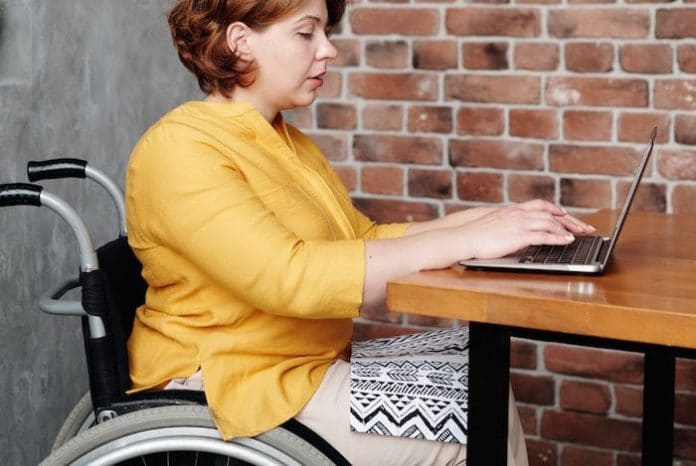 Woman in Wheelchair Reading Laptop