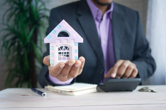 Businessman holding house model