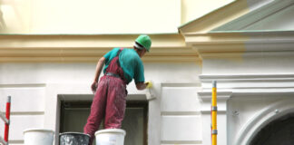 Person painting a house