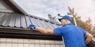 Person cleaning gutter