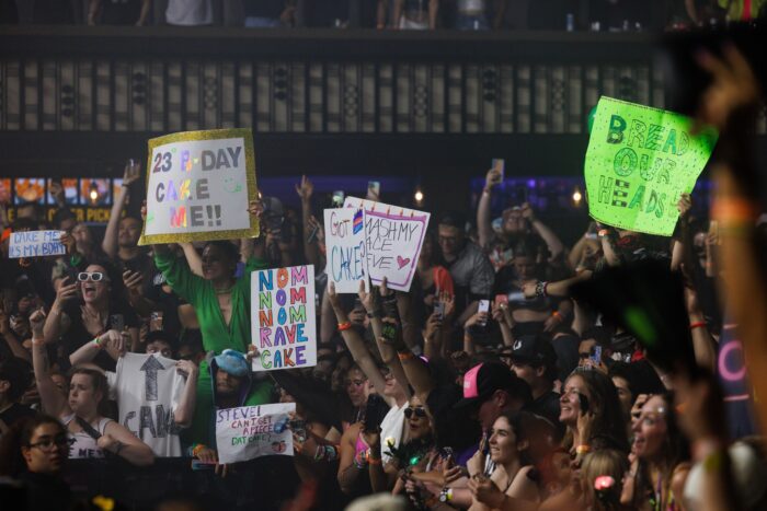 Steve Aoki's signature move is to throw cake at the lucky concert-goers holding up the best "CAKE ME" signs.