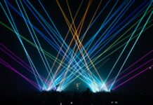 Steve Aoki stands amongst vibrant, crisp, and colorful laser displays at The Armory in Minneapolis.