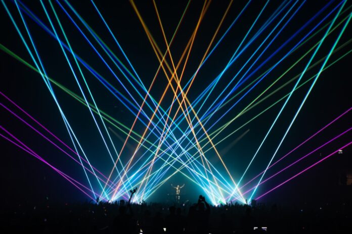 Steve Aoki stands amongst vibrant, crisp, and colorful laser displays at The Armory in Minneapolis.
