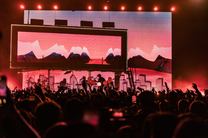 Porter Robinson's unique and asymmetrical stage setup included multiple layered screens, a live band, and musical light bulbs. Photo credit: Brez Media