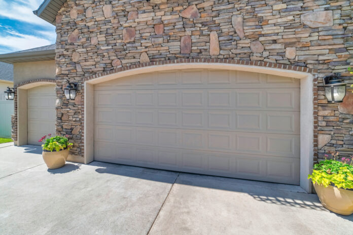 Two beige sectional garage doors with arched bricks door opening Make Home Garage Door Quieter