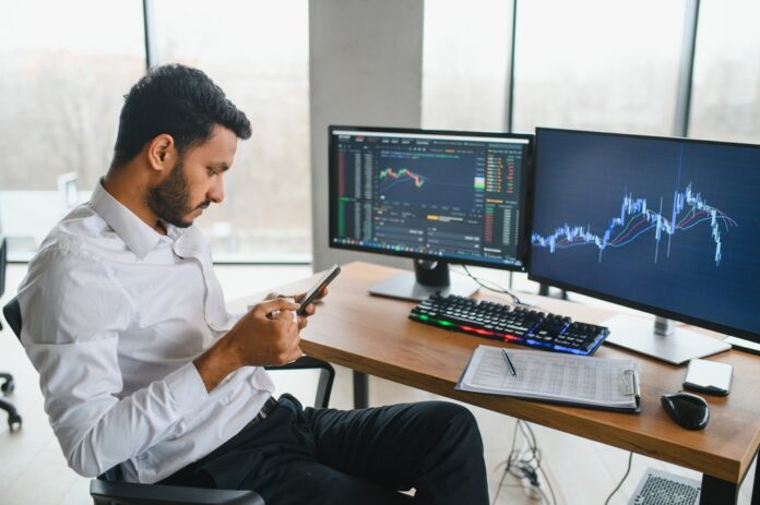 Thoughtful concentrated indian business man entrepreneur investor manager using computer, watching webinar working in office analyzing online data market thinking doing web research looking at laptop. Forex Trading vs Futures Trading