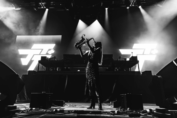Woman performs on stage during EDM music event.