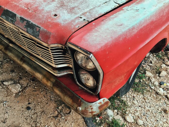 A front of an old vintage red car Sell to Junk Car Buyers
