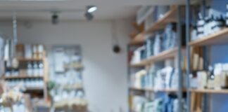 How Store Layout Influences Shopper Decisions A well-organized retail store interior with wooden shelves displaying neatly arranged home goods, bath products, and decor items along a central aisle.