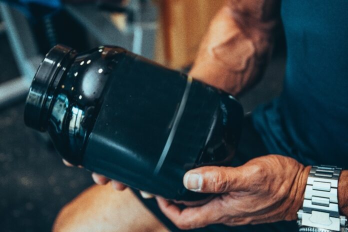 detail-of-a-protein-bottle-in-the-hands-of-a-muscu-2026-03-13-04-24-23-utc legion-protein