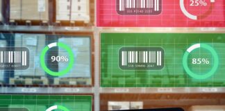 A worker holds a tablet showing warehouse data while shelves of goods display digital inventory tracking metrics.