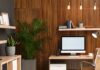 Top Home Office Upgrades for a Growing Business A home office features a wooden slat accent wall, a desk with a computer, a tan office chair, and several potted plants.
