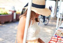 Pop-Up Mistakes That Hurt Home-Based Sellers a smiling woman browsing colorful handmade souvenirs at an outdoor market kiosk on a sunny street with hanging displays.