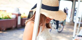 Pop-Up Mistakes That Hurt Home-Based Sellers a smiling woman browsing colorful handmade souvenirs at an outdoor market kiosk on a sunny street with hanging displays.