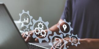 A person uses a laptop with digital icons representing automation, workflows, and business system management tools.