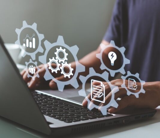 A person uses a laptop with digital icons representing automation, workflows, and business system management tools.